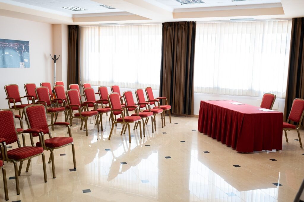 poltroncine e tavolo relatori nella sala conferenze del Majestic